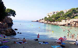 The beach at the cove on a summer day, parasols on the sand and turquoise water